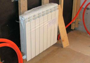 При креплении радиатора на деревянную стену нужно учитывать возможность ее усадки