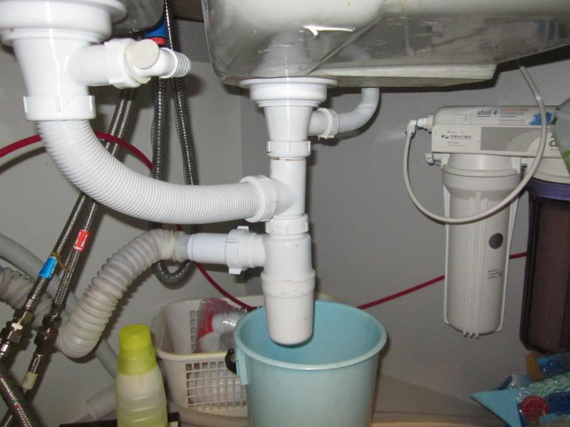 В раковине на кухне булькает вода. Гидрозатвор сифон канализационный 110. Течет труба под раковиной. Трубы под раковиной на кухне.